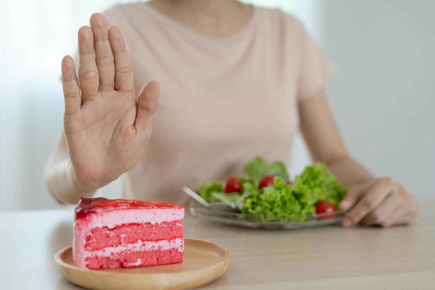 conceito de dieta. as mulheres recusam bolo e comem salada para uma boa saúde. foto