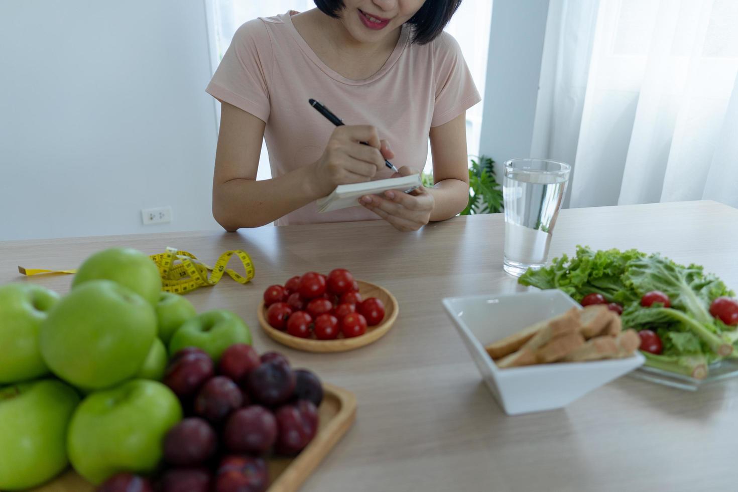 comida saudável e dieta cetônica. as mulheres planejam dietas para uma forma esbelta e saudável. mulher comendo maçã e legumes foto