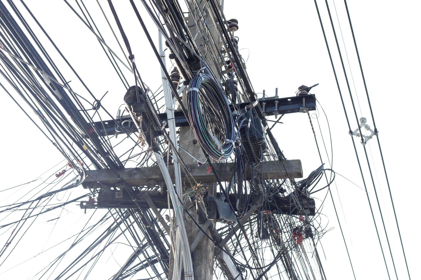 pólo elétrico closeup com fios e cabos de comunicação confusos isolados no fundo branco. foto