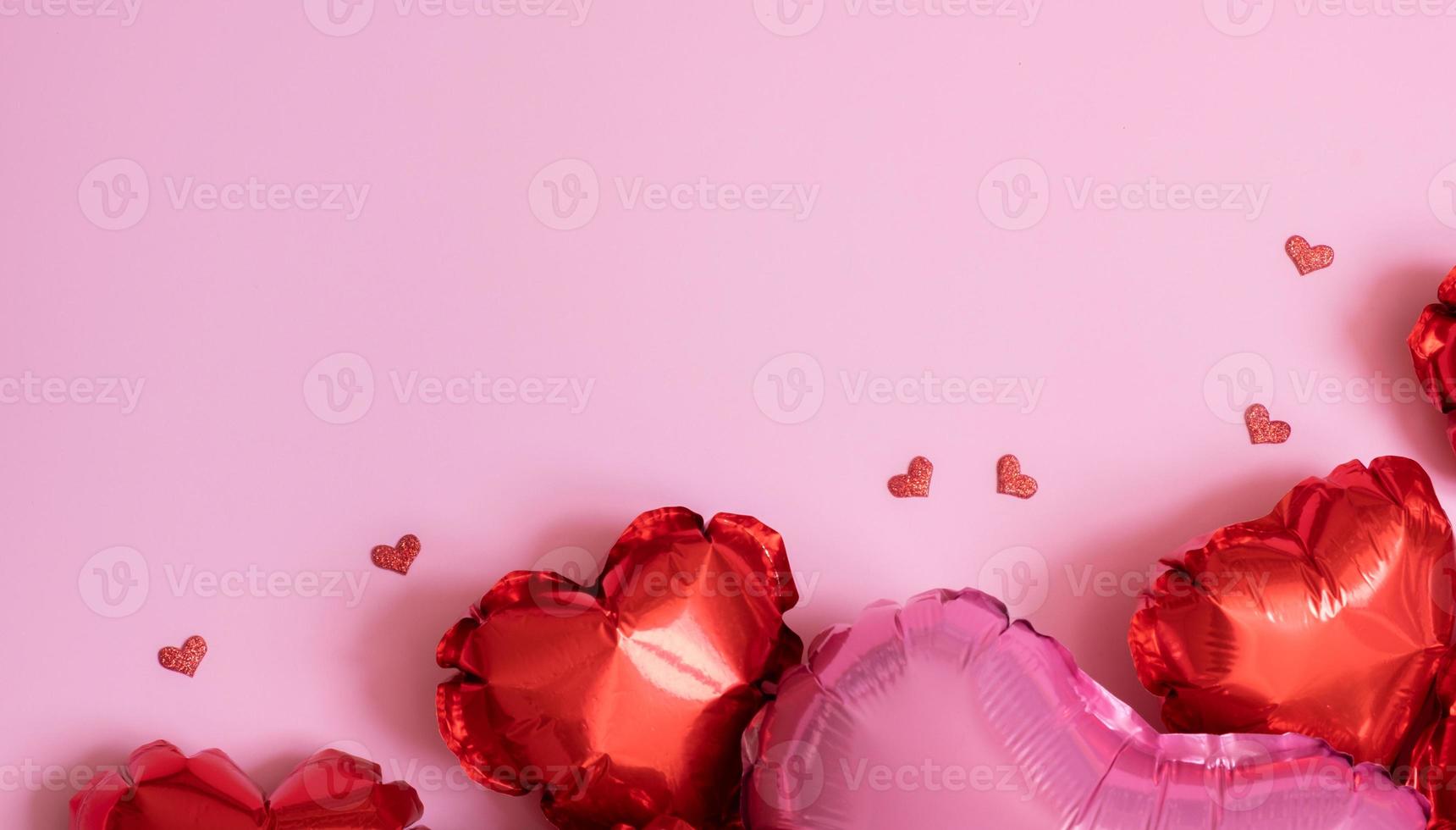 fundo de dia dos namorados com espaço de cópia e forma de coração vermelho pequenos e grandes balões de folha em plano de fundo rosa foto