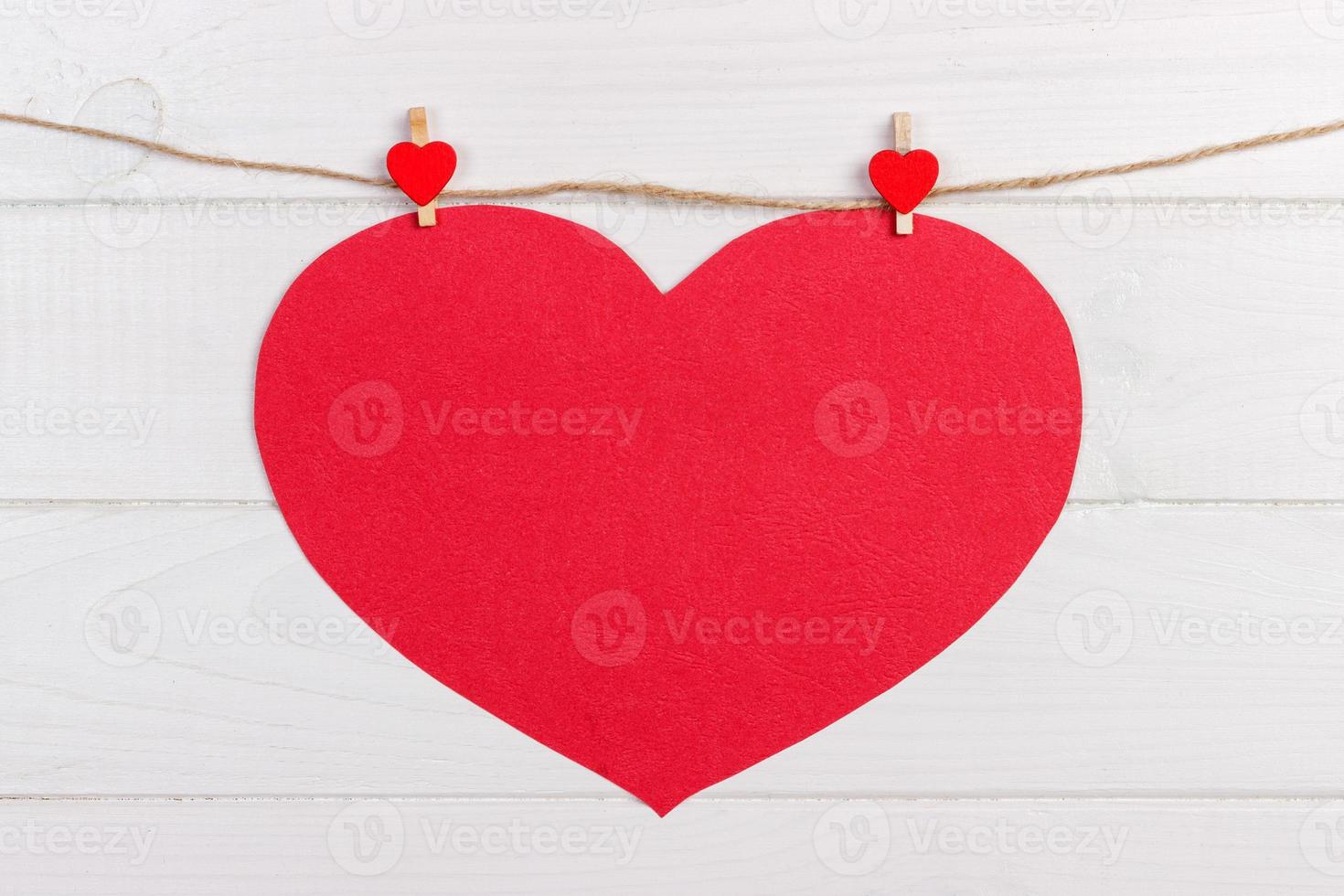 grande amor coração vermelho pendurado no fundo de textura de madeira, conceito de cartão de dia dos namorados foto