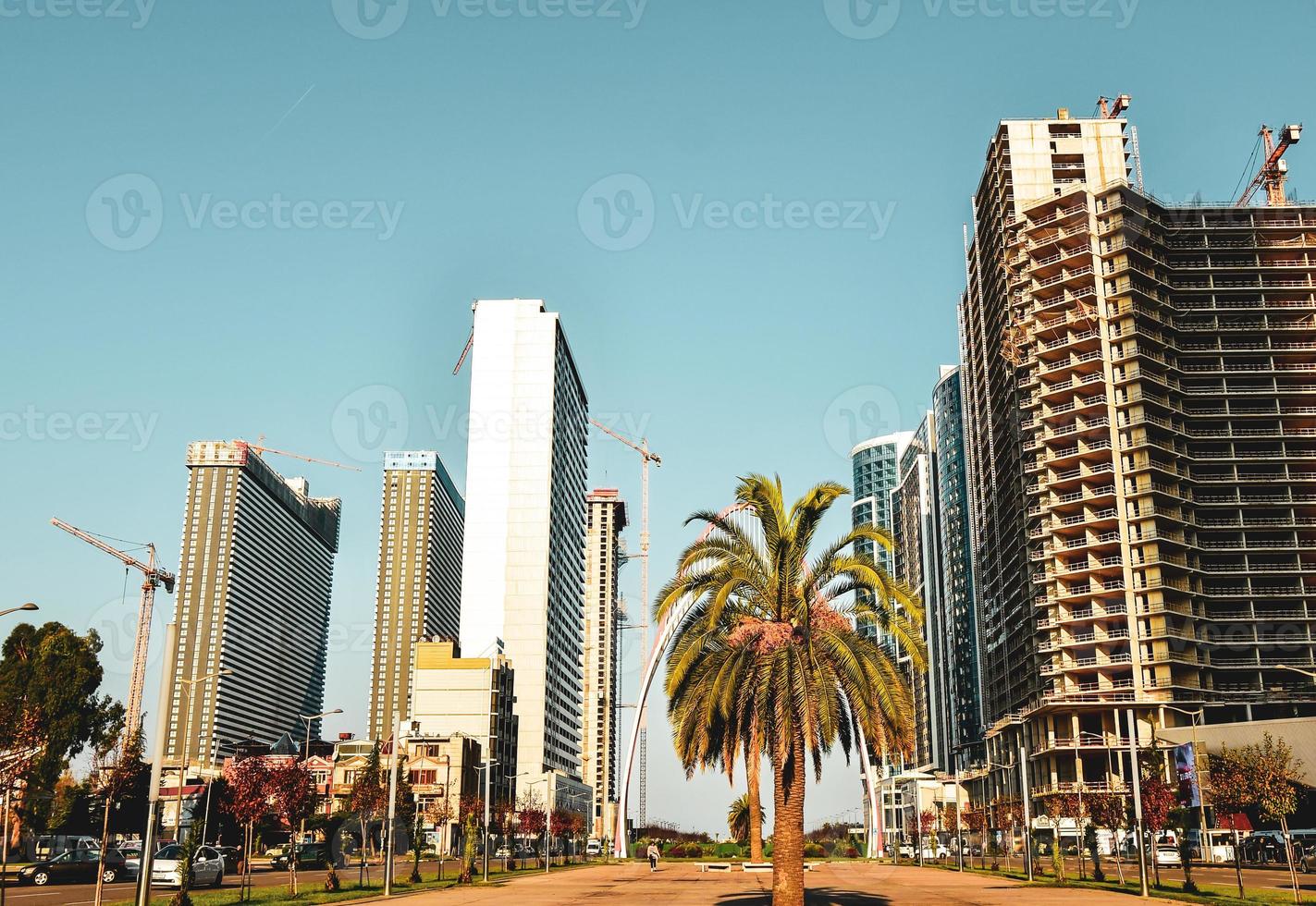 zoom em lapso de tempo dinâmico panorama da cidade de batumi com carros no trânsito e canteiro de obras imobiliárias com guindastes em dia ensolarado. conceito de desenvolvimento imobiliário de trabalho de construção foto