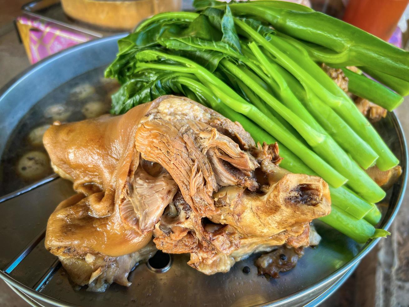 Perna de porco estufada com molho de molho doce comida chinesa ou comida tailandesa asiática Perna de porco estufada na panela fumegante com ovos couve vegetal foto