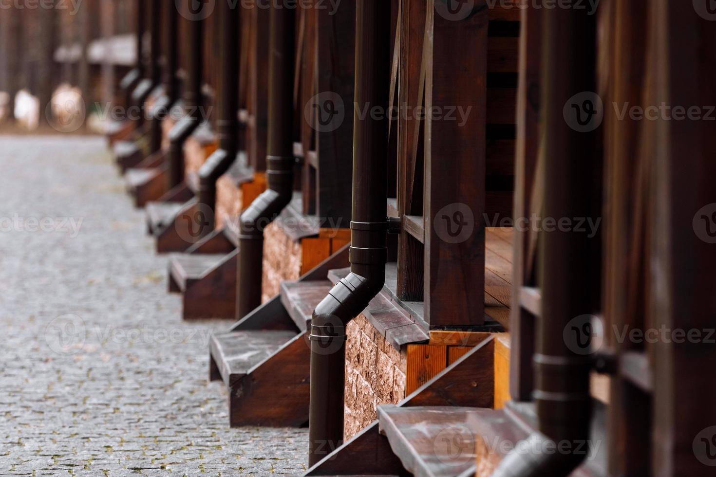 linha de casa de campo de casas rústicas de madeira com calhas de metal para o telhado. sistema de drenagem. casinha para alugar na natureza. estilo ecológico. vista lateral foto