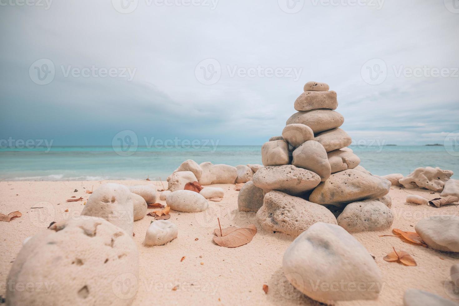 torres de pedras dolomitas equilibradas na praia em um dia nublado. pedra zen inspiradora e meditativa na praia foto