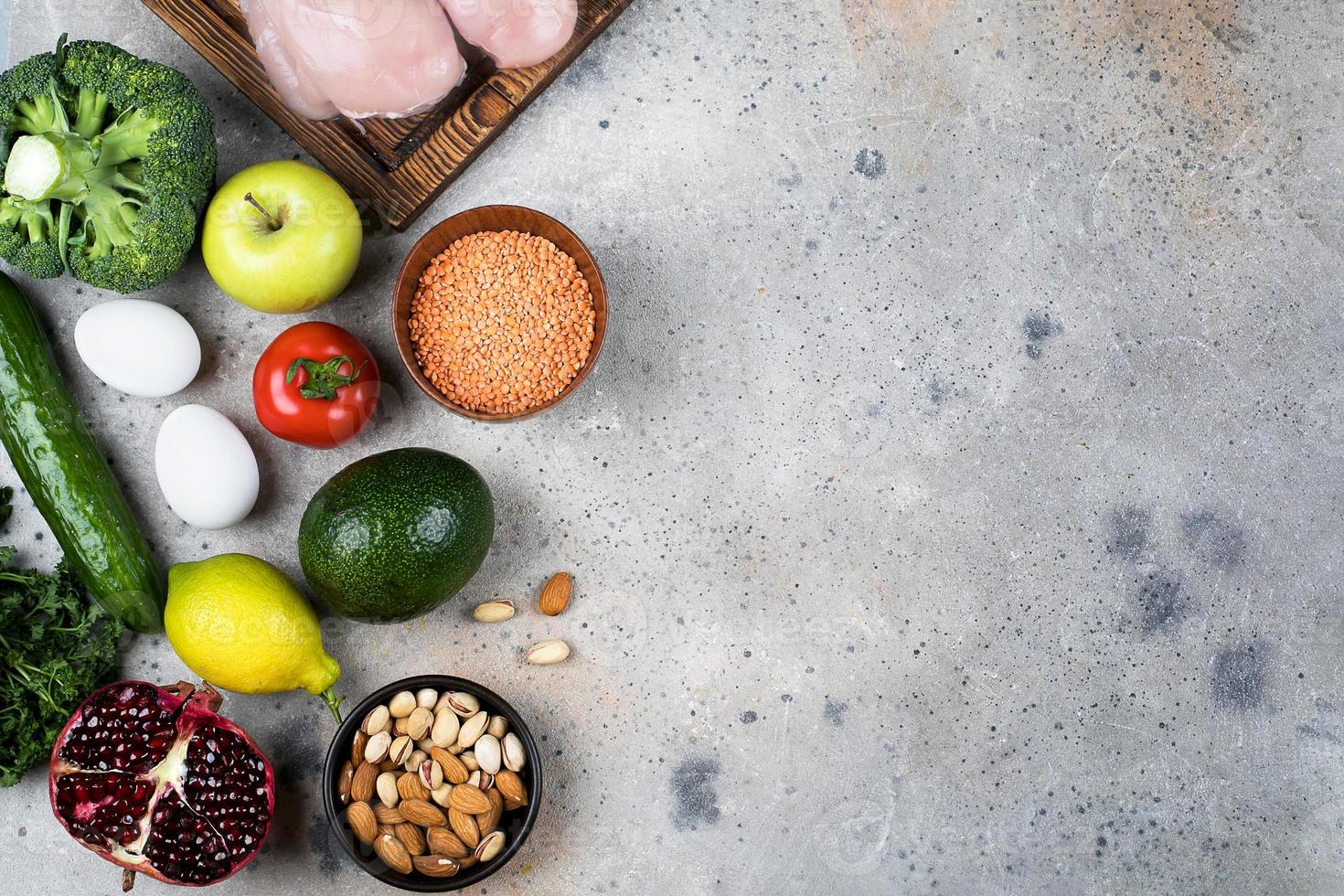 conceito de nutrição alimentar. carne, legumes, frutas e produtos de feijão no fundo da mesa de pedra. vista superior, configuração plana, copie o espaço foto