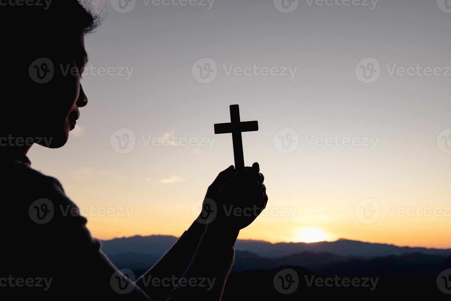 silhueta da mão de uma mulher cristã rezando, mulher segurando um crucifixo rezando, espiritualidade e religião, mulher orando a deus. conceito de cristianismo. foto