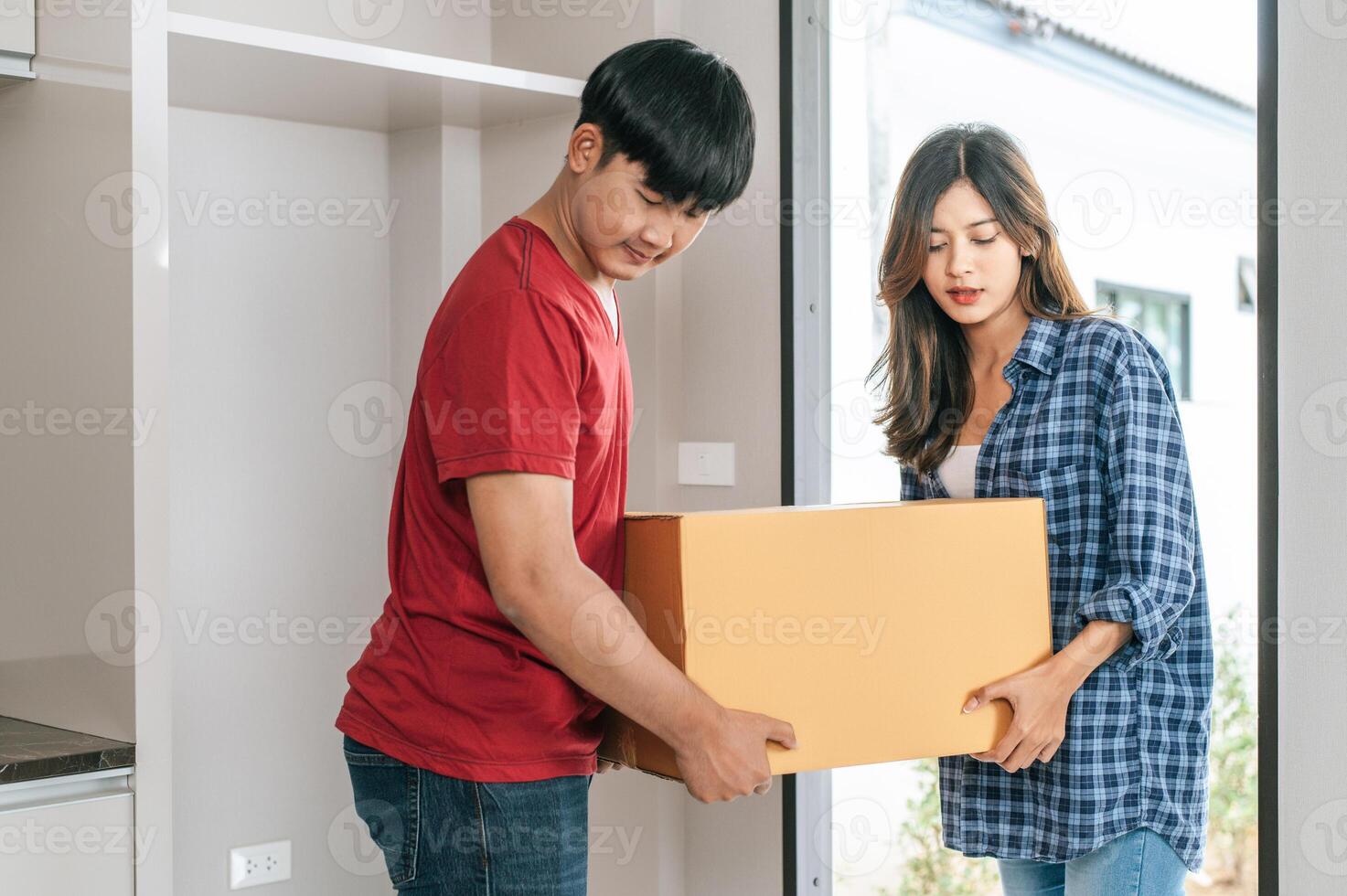 jovem casal movendo pacote para casa nova foto