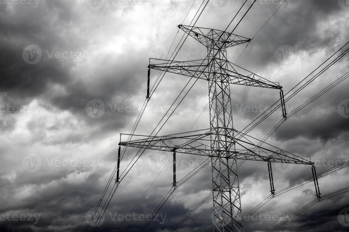 linhas de transmissão de eletricidade e nuvens escuras no céu foto