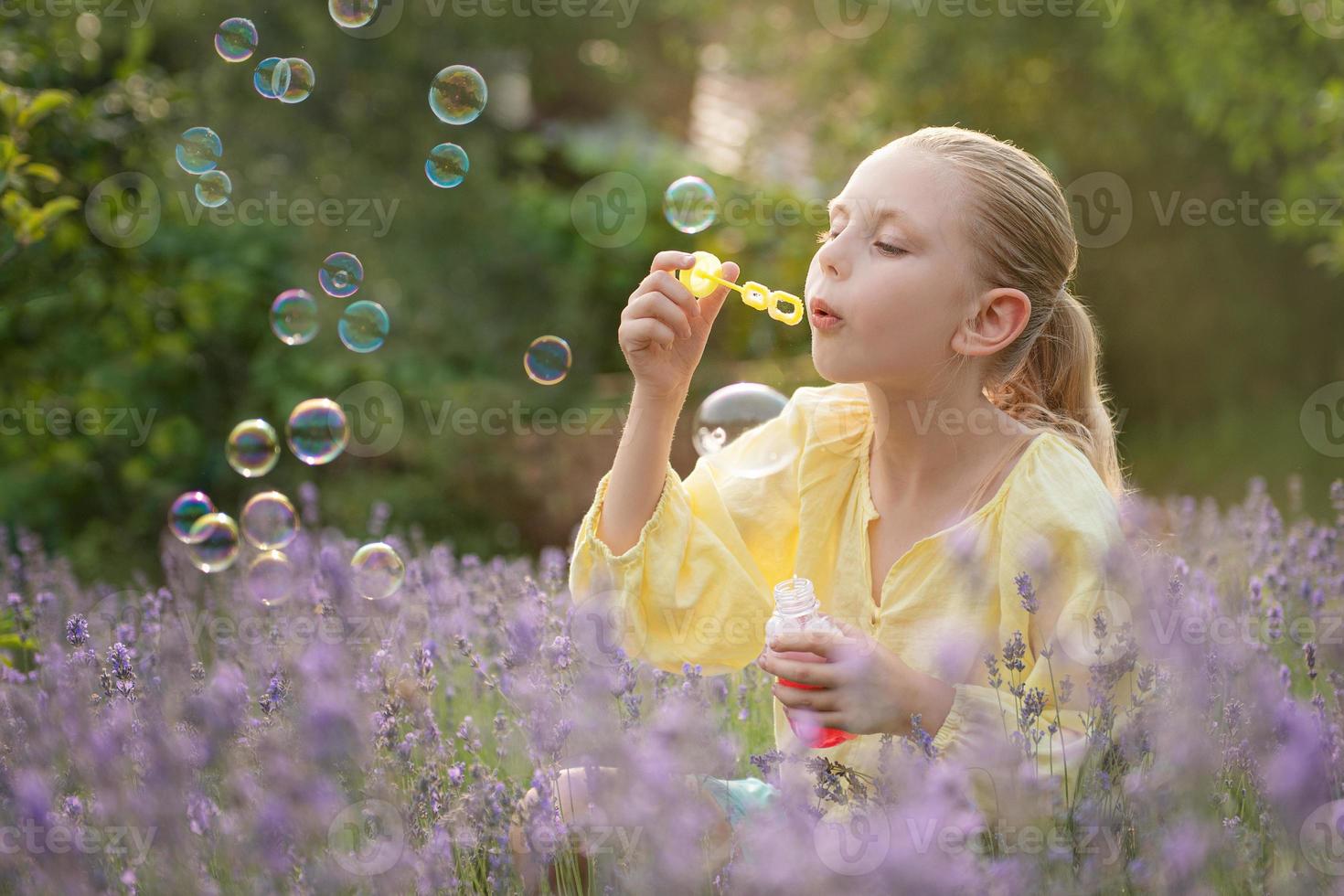 linda garotinha em um campo com lavanda. foto