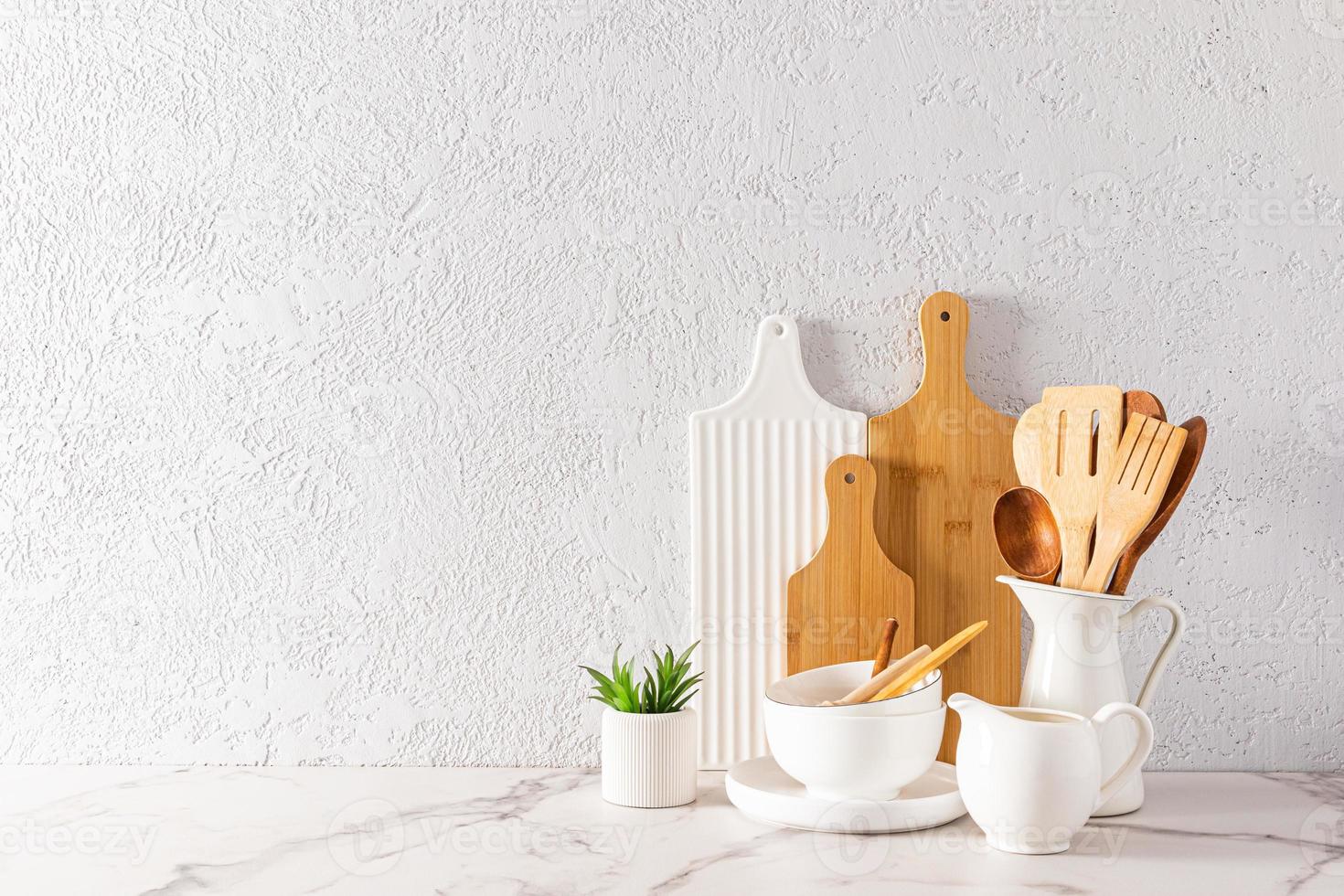 parte do interior de uma cozinha moderna. belos utensílios de cozinha em uma bancada de mármore branco. cozinha ecologicamente limpa. cópia do espaço. foto