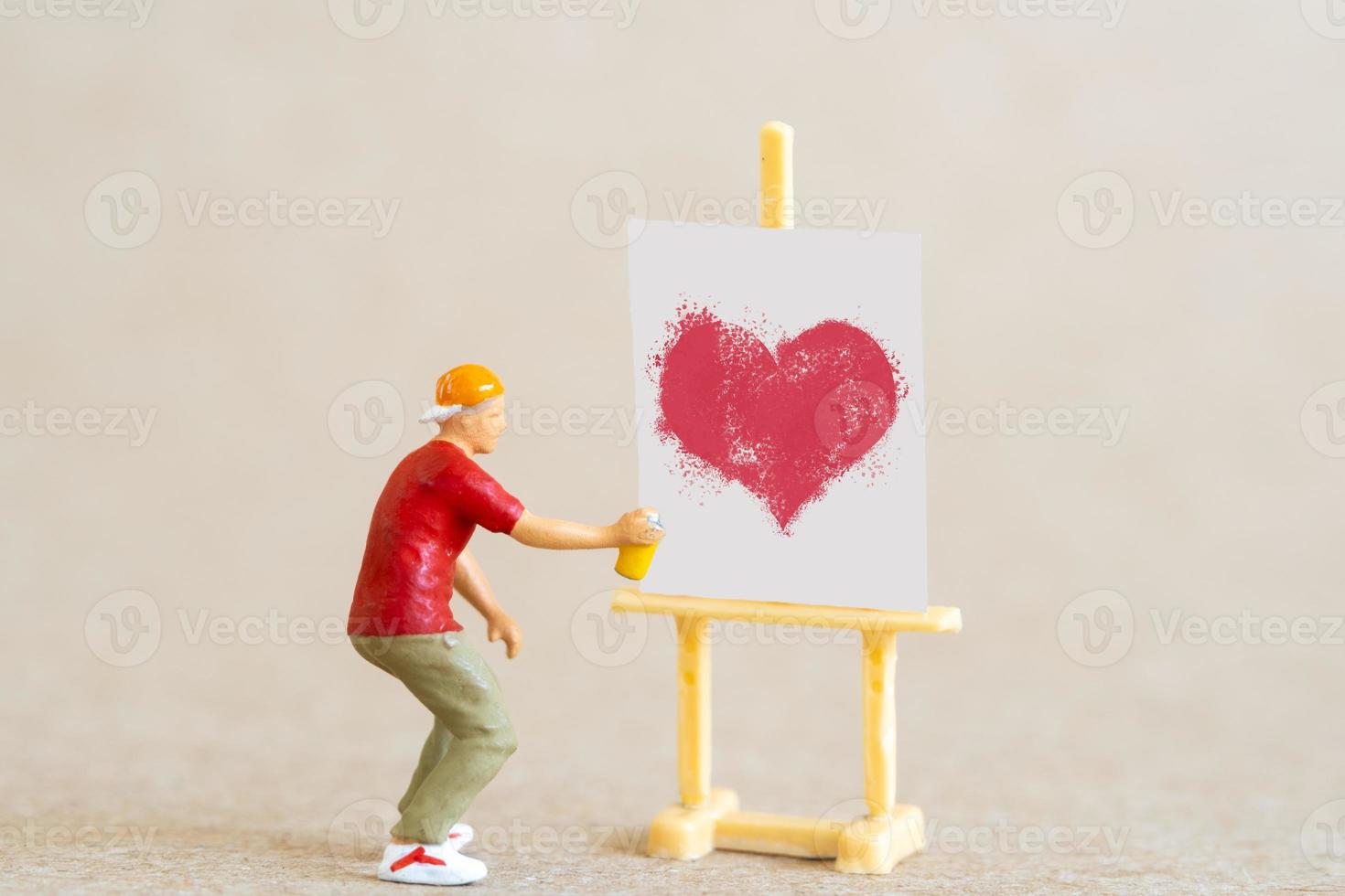 artista segurando dispensador e pulverizando com formas de coração vermelho, conceito de dia dos namorados foto