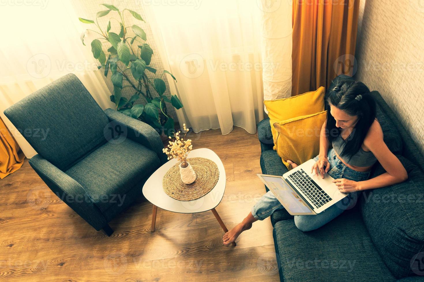 vista superior jovem usando laptop, digite sentado no sofá em casa, linda garota fazendo compras ou conversando online na rede social, trabalhando, fazendo compras, freelancer trabalhando no computador foto