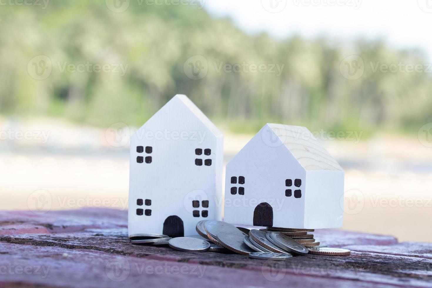 casa branca com pilhas de moedas. idéias de economia de dinheiro para imóveis. foto