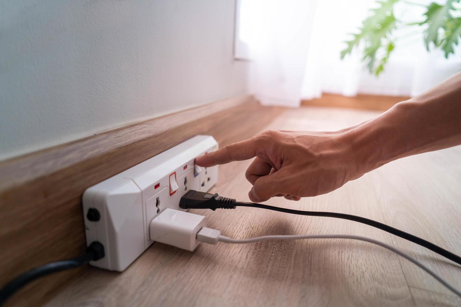 economizar eletricidade, economia de energia e proteção ambiental. o dedo do homem pressiona o botão para desligar a luz. uso econômico de eletricidade foto