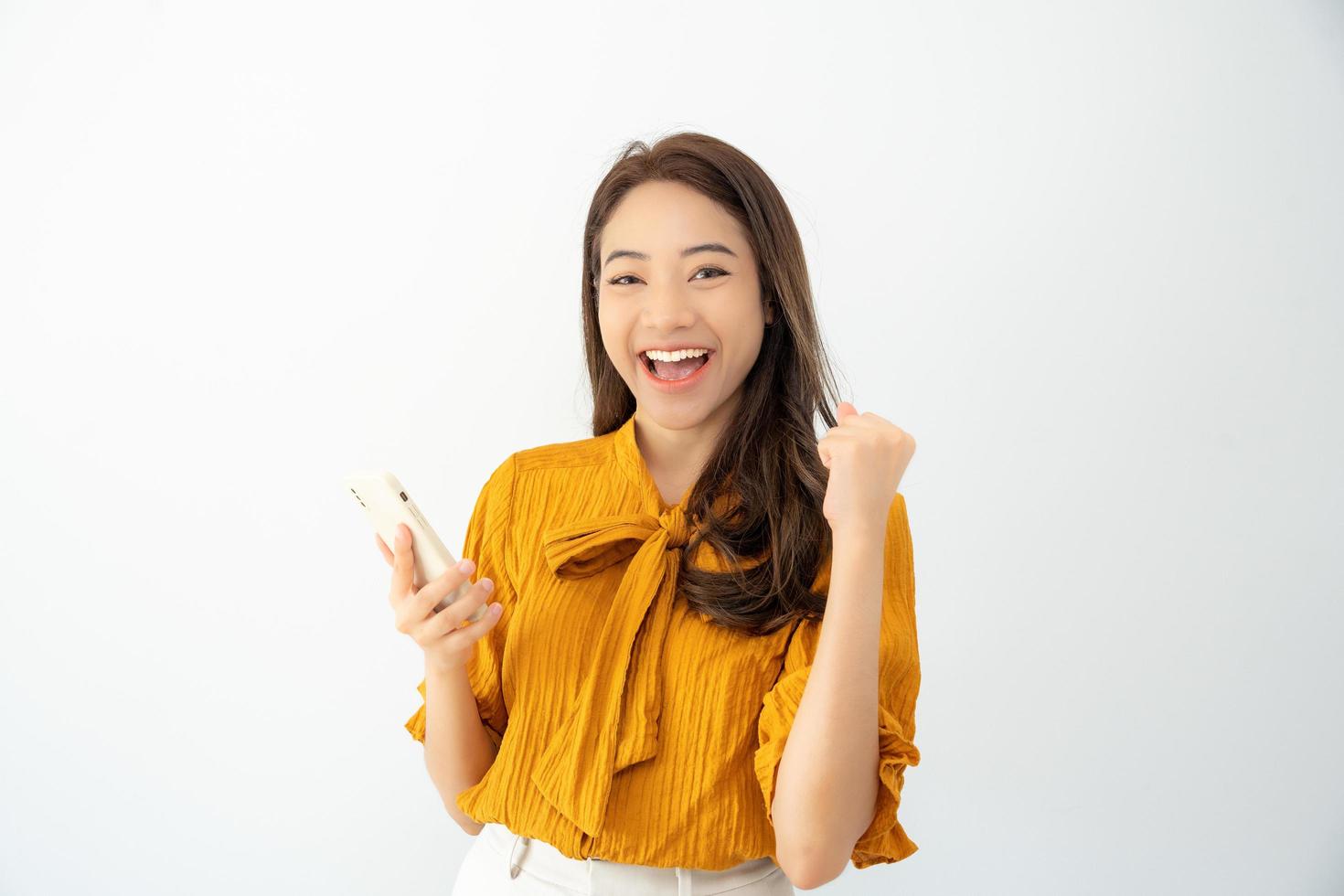 mulher bonita asiática saiu da expressão do rosto de surpresa. fêmea se sente chocada com o telefone. sorriso emocionante e alegria adorável feliz. muito divertido e divertido relaxar. uau, garota segurando o smartphone. foto