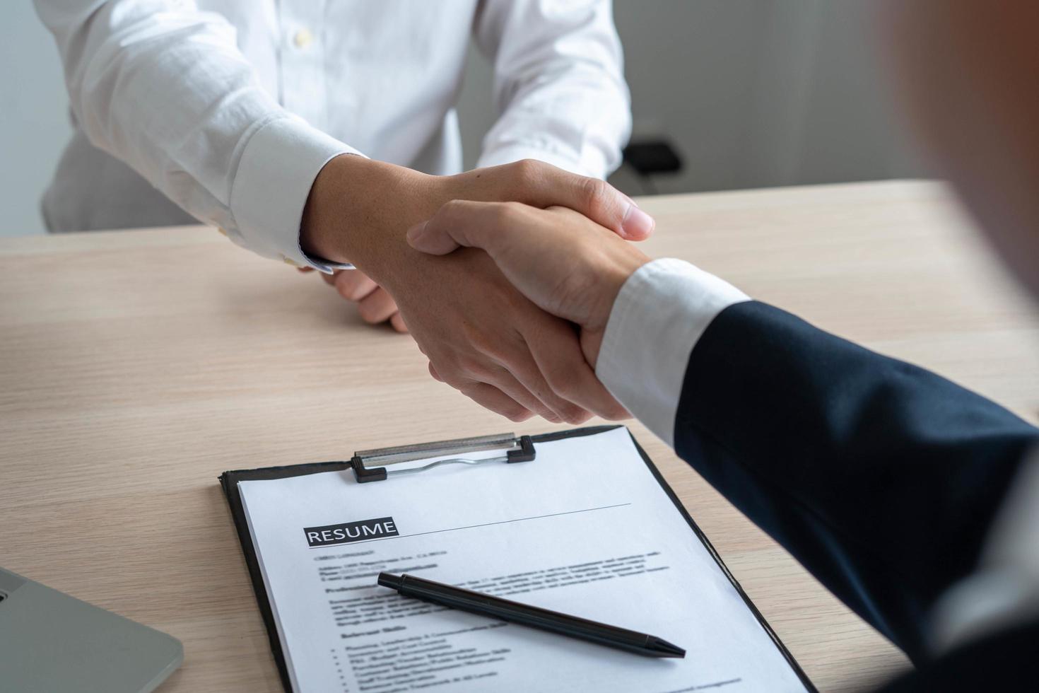 empresários e candidatos a emprego apertam as mãos depois de concordar em aceitar um emprego e aprová-lo como funcionário da empresa. ou um acordo de joint venture entre os dois empresários foto