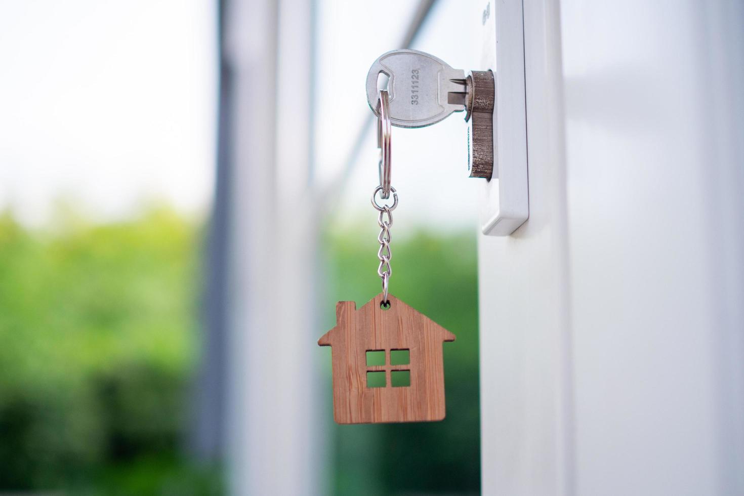 chave de casa com chave de casa, feita de madeira no buraco da fechadura pronta para vender o conceito de imóveis. foto