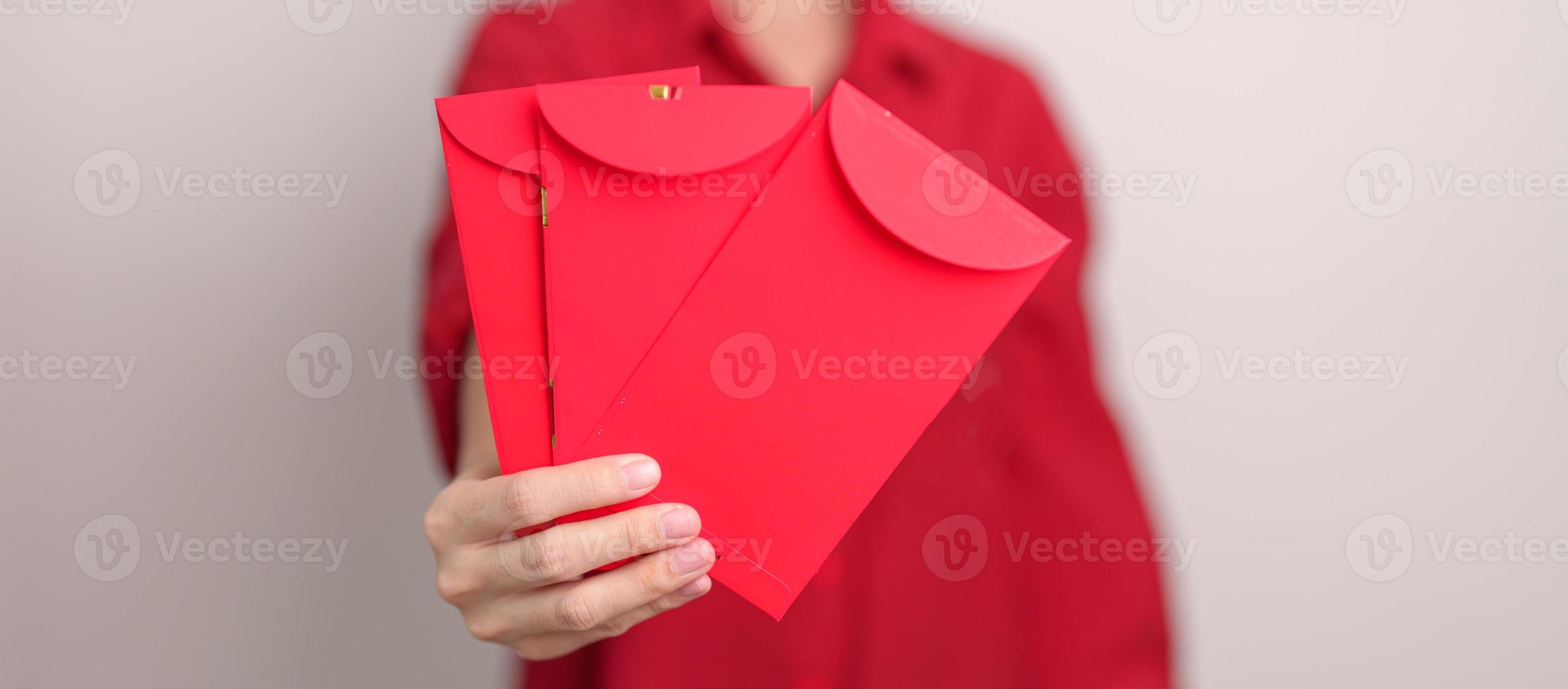 mulher segurando envelope vermelho chinês, presente de dinheiro para feliz feriado do ano novo lunar foto