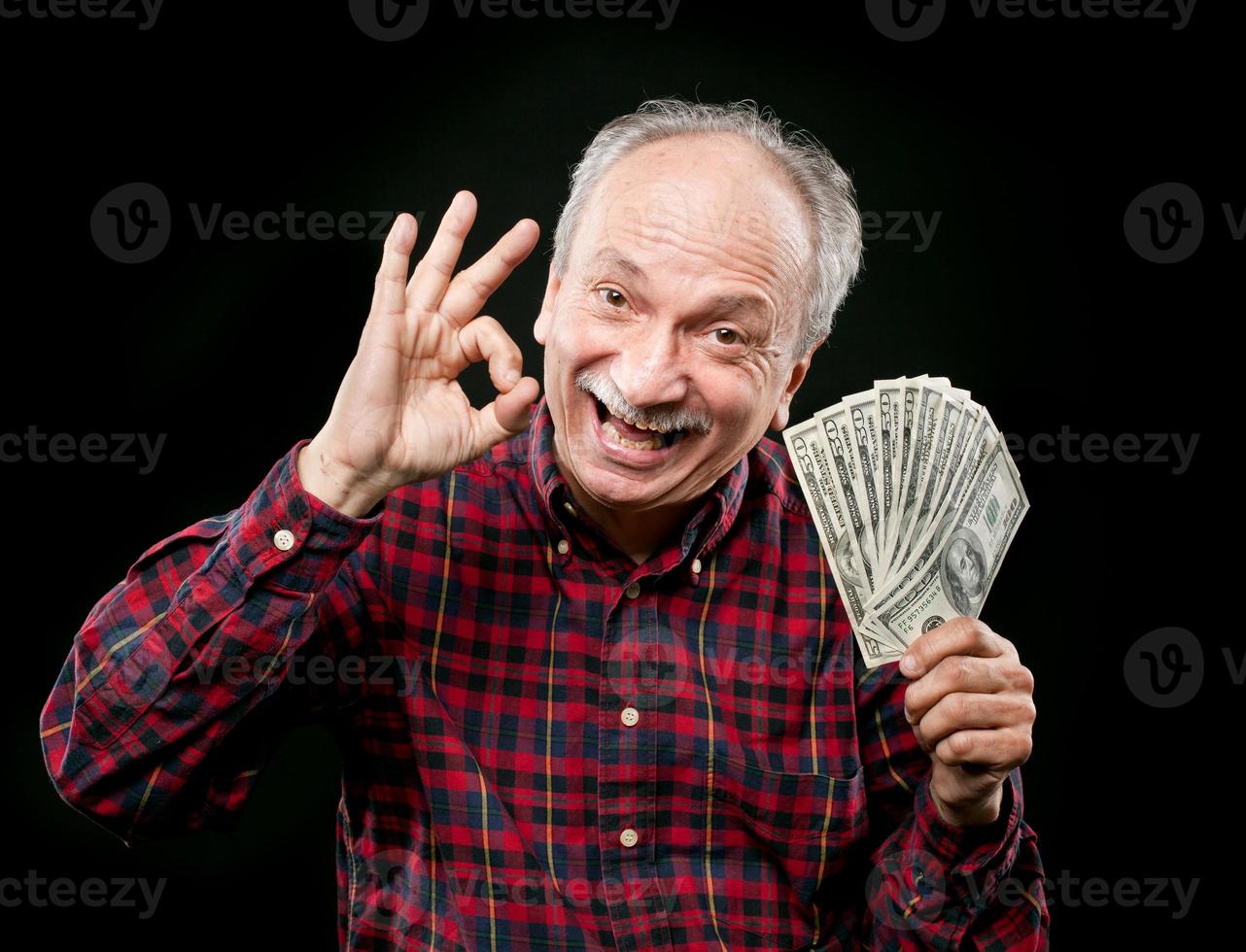 homem idoso mostrando fã de dinheiro foto