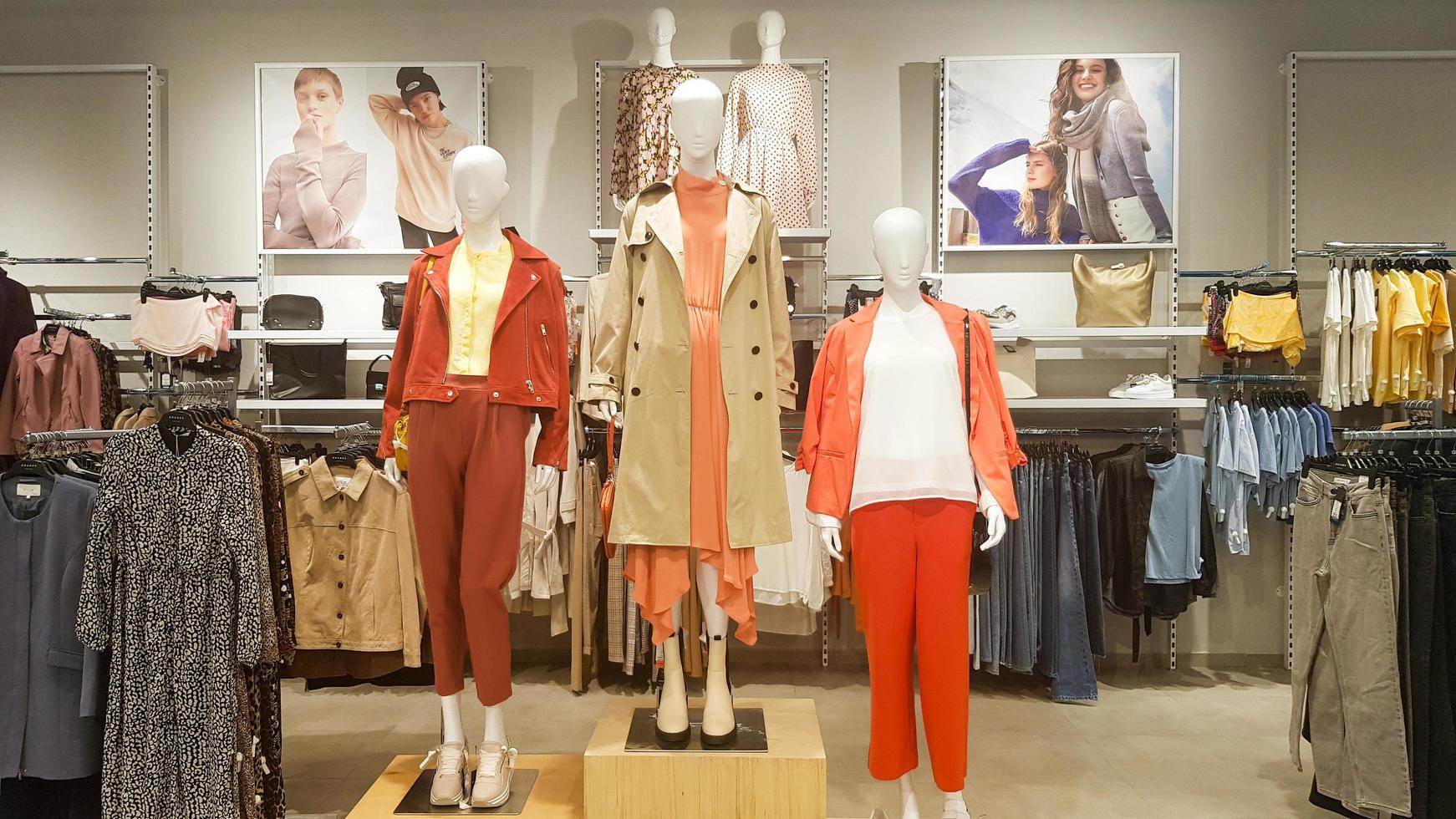 três manequins vestidos em pé em uma loja. loja de roupas femininas casuais  no shopping. manequins