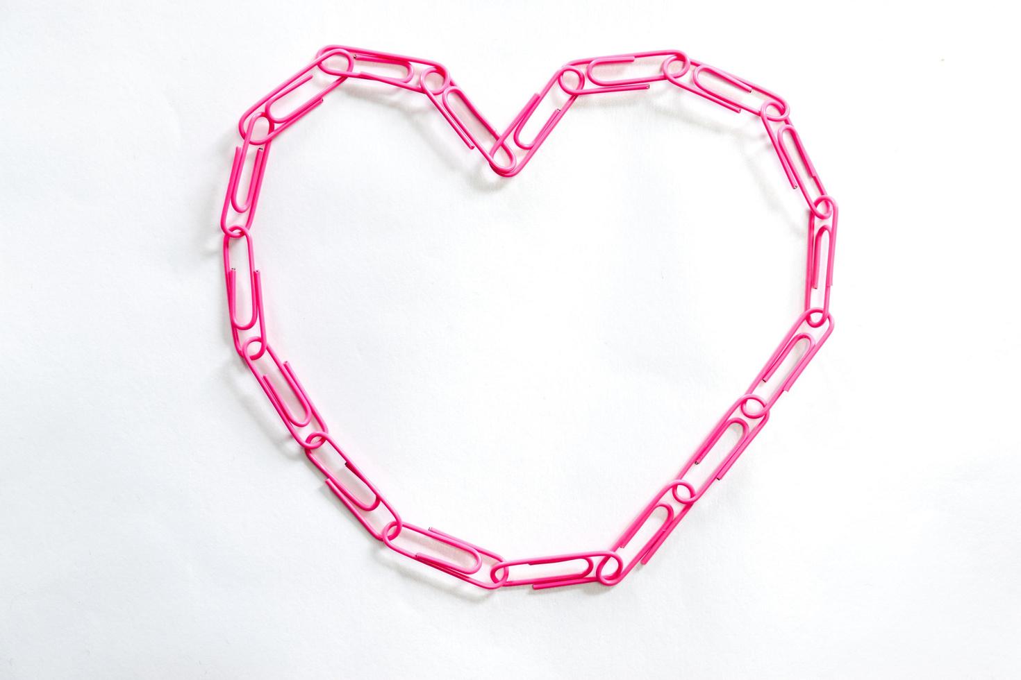 clipes de papel rosa em forma de coração em fundo branco foto