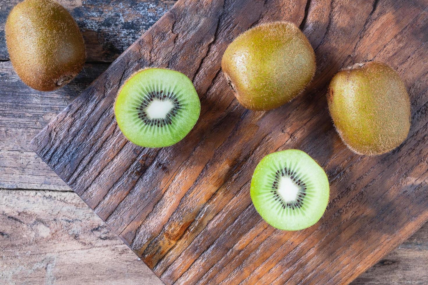 kiwi inteiro na tábua de corte foto