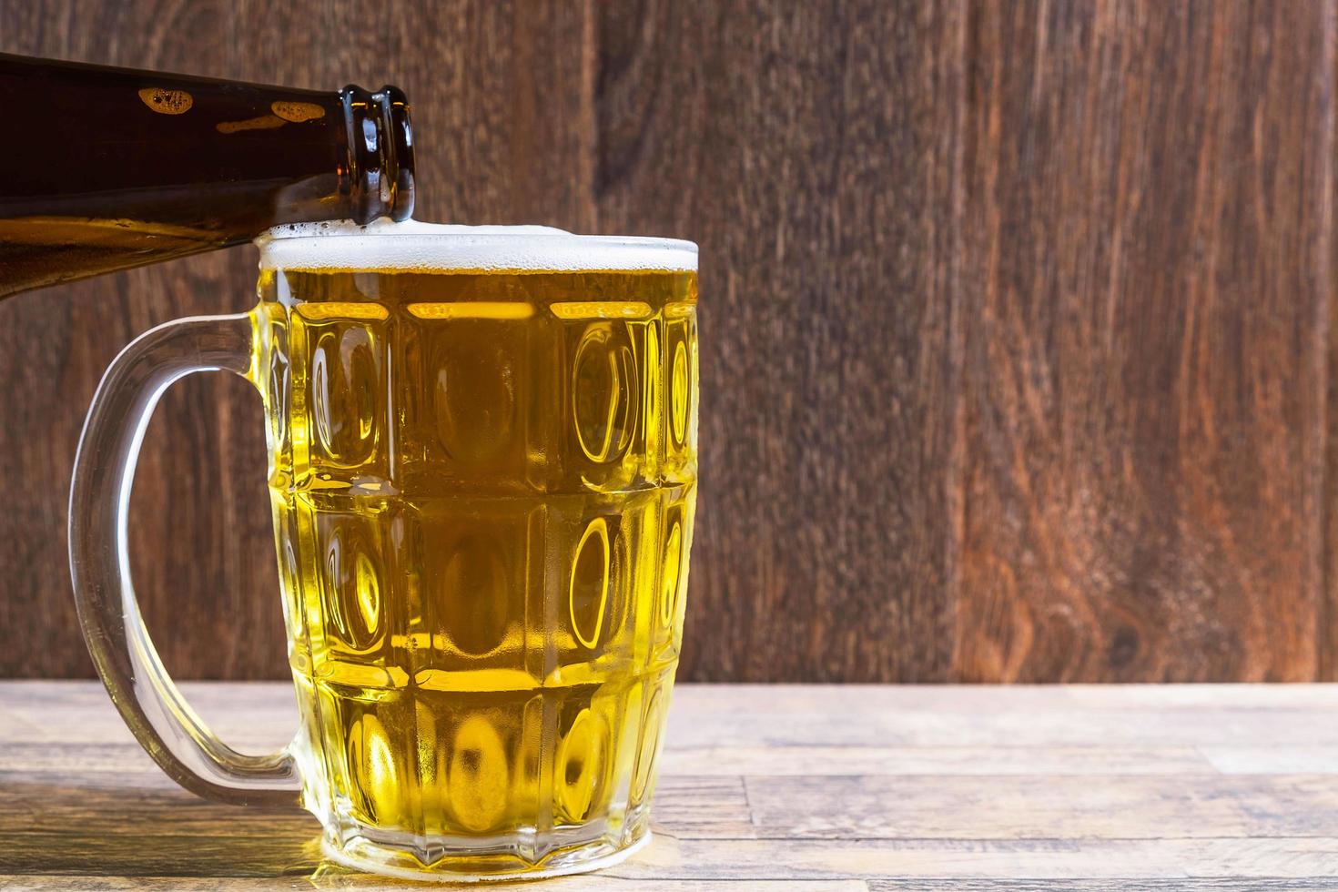 derramando cerveja em uma caneca foto