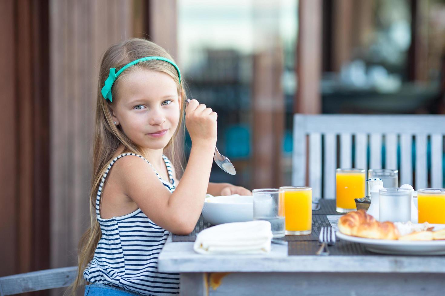 garota tomando café da manhã em um café ao ar livre foto