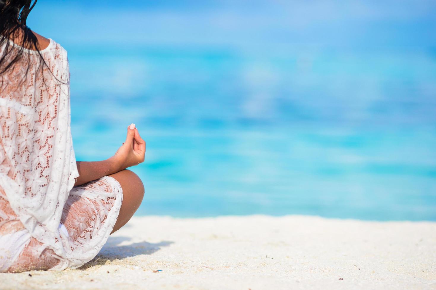 mulher meditando em uma praia com espaço de cópia foto
