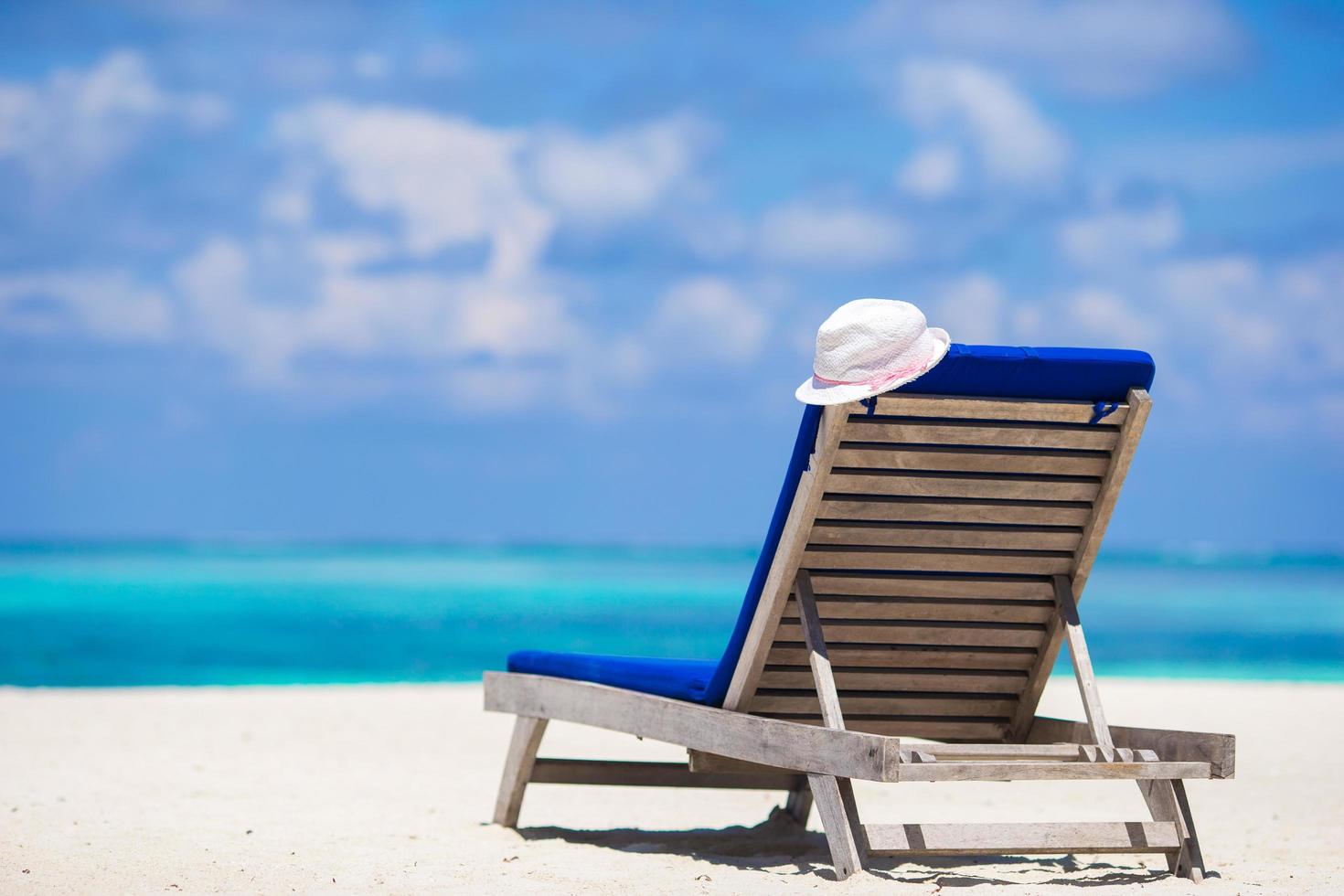 poltrona e chapéu branco em praia tropical foto