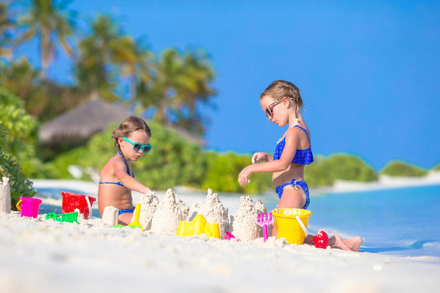 duas meninas construindo um castelo de areia foto