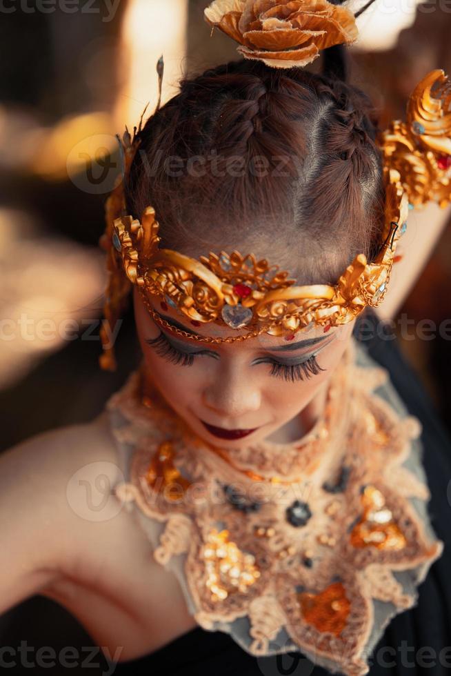 retrato de mulher asiática usando uma coroa de ouro e colar de ouro com sua linda maquiagem em vestido preto foto