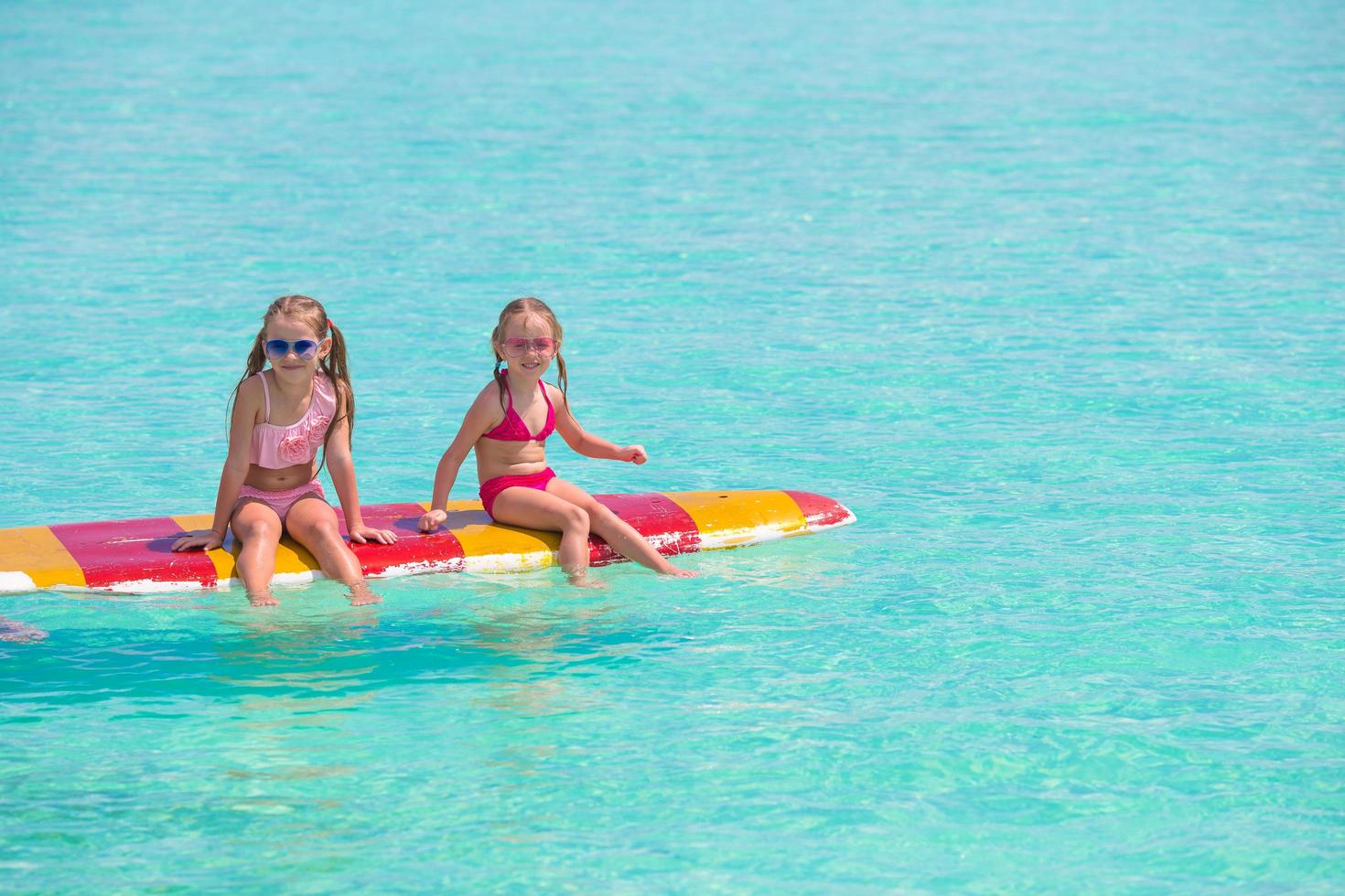 duas garotas em uma prancha de surf foto