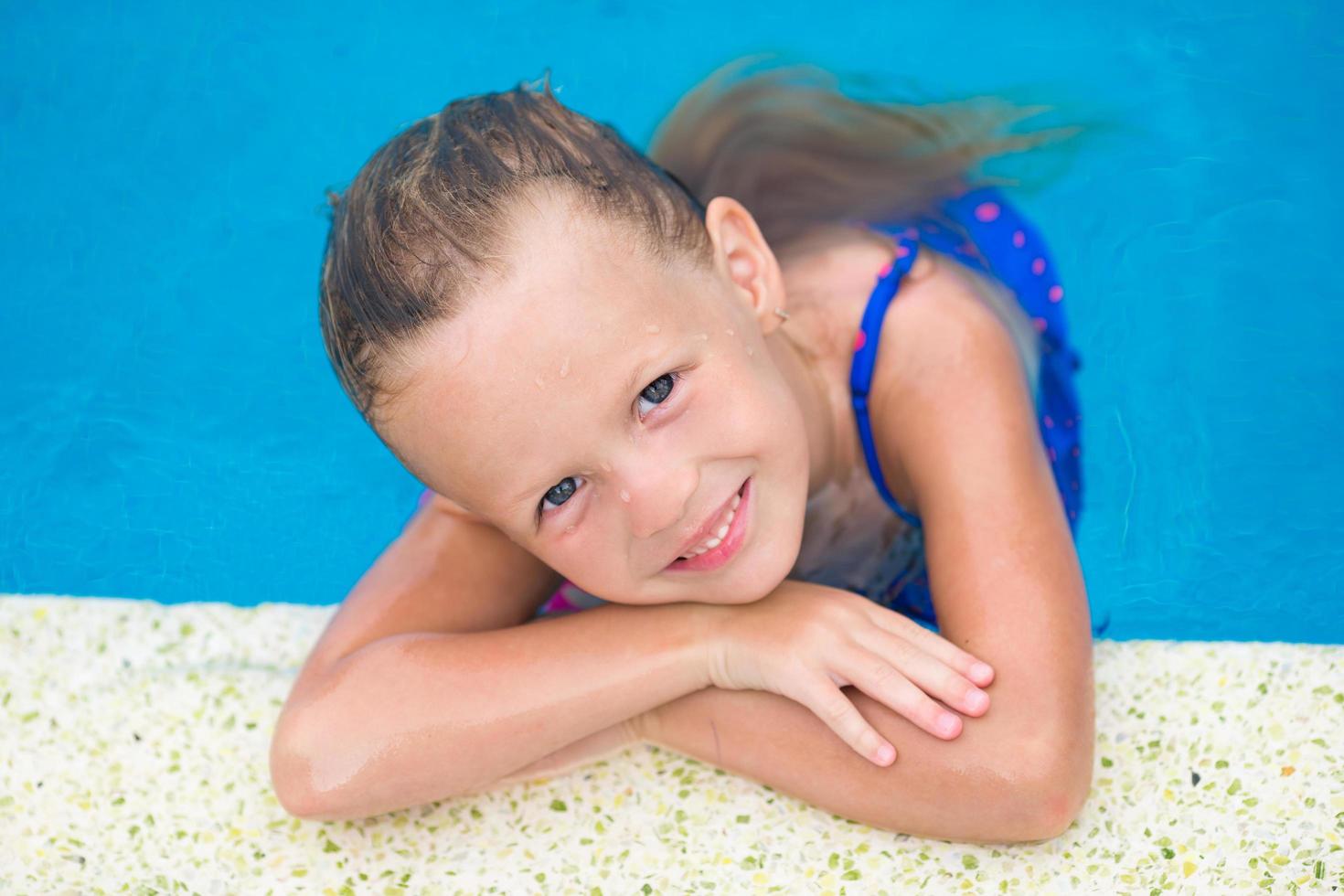 retrato de menina sorridente em uma piscina foto