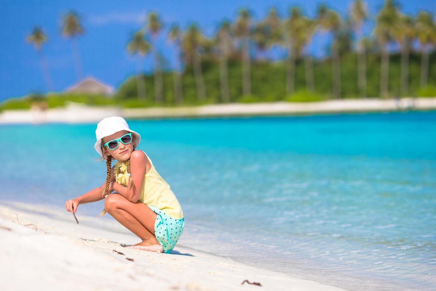 menina brincando na areia na praia foto