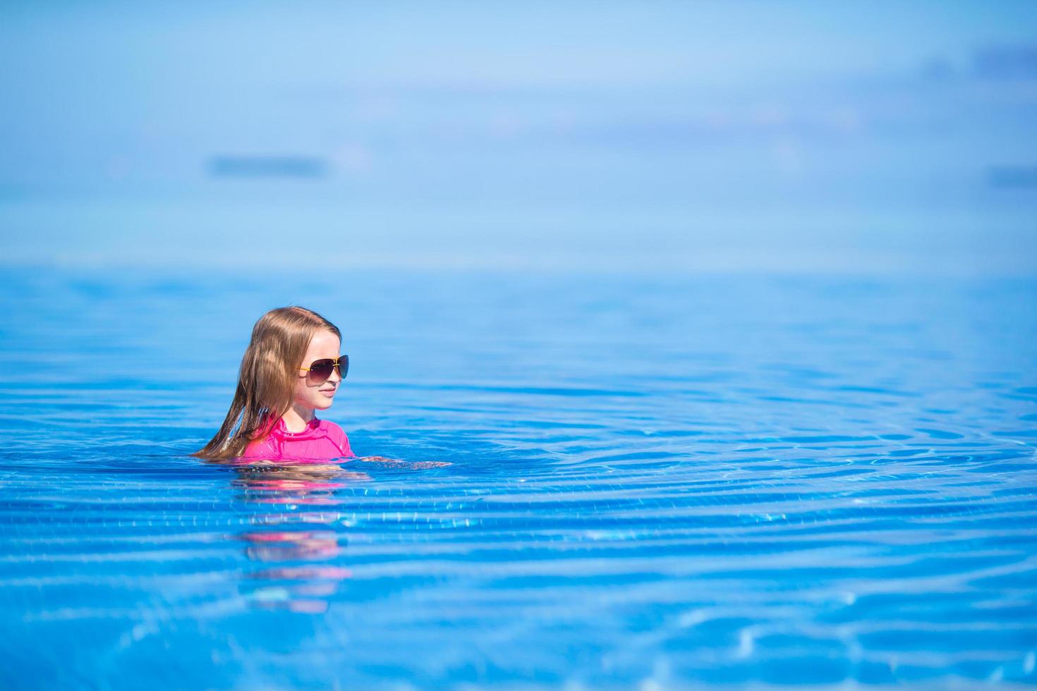 menina nadando na piscina foto