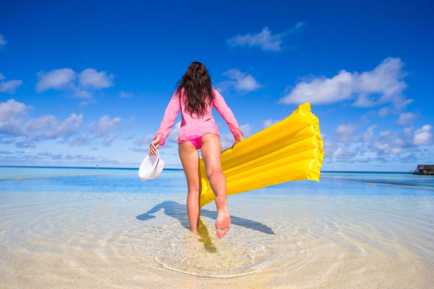 mulher com floatie na praia foto