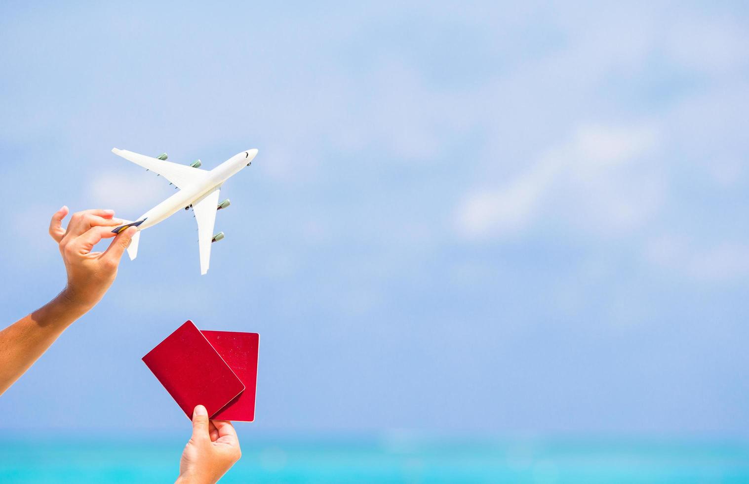 mãos segurando passaportes e um avião de brinquedo foto