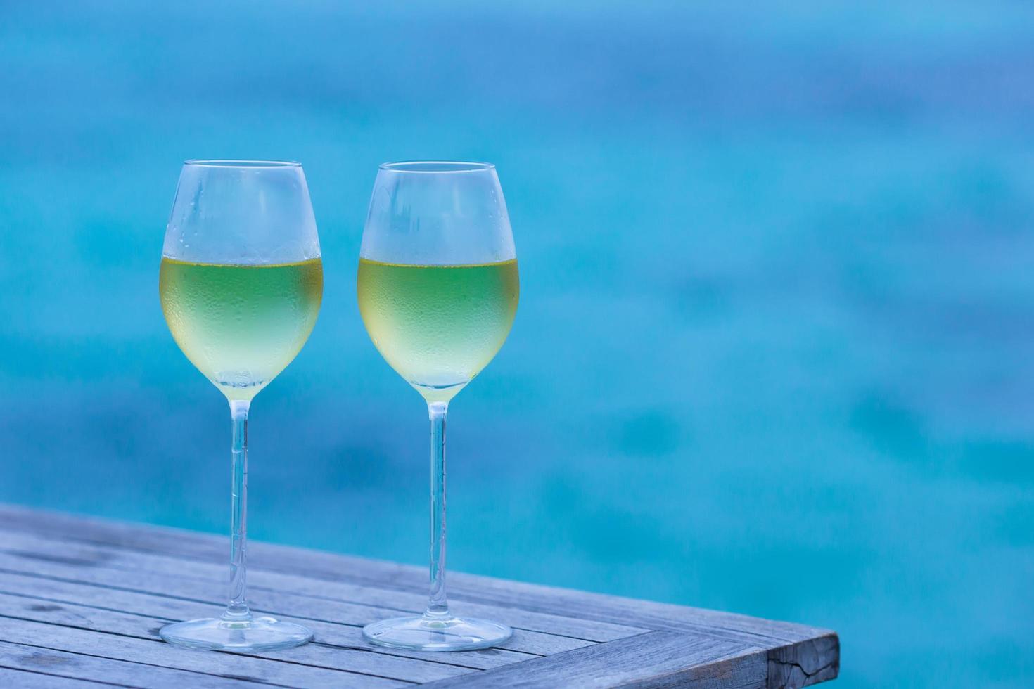 taças de vinho branco na piscina foto