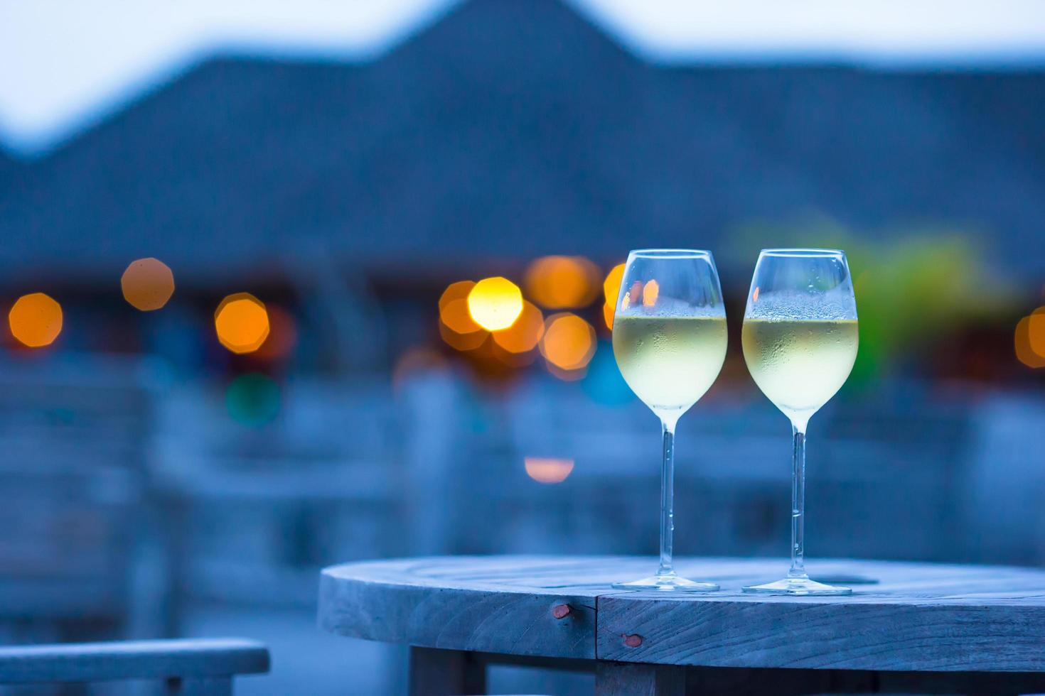 duas taças de vinho branco em um café ao ar livre foto