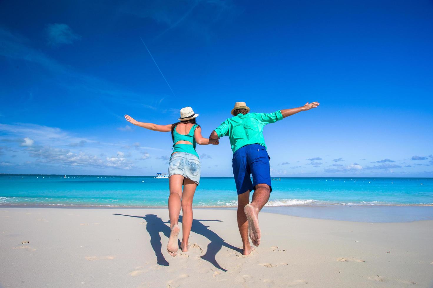 casal correndo em direção ao oceano foto