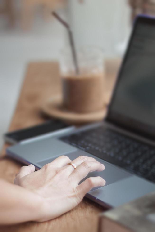 pessoa trabalhando em um computador em uma cafeteria foto