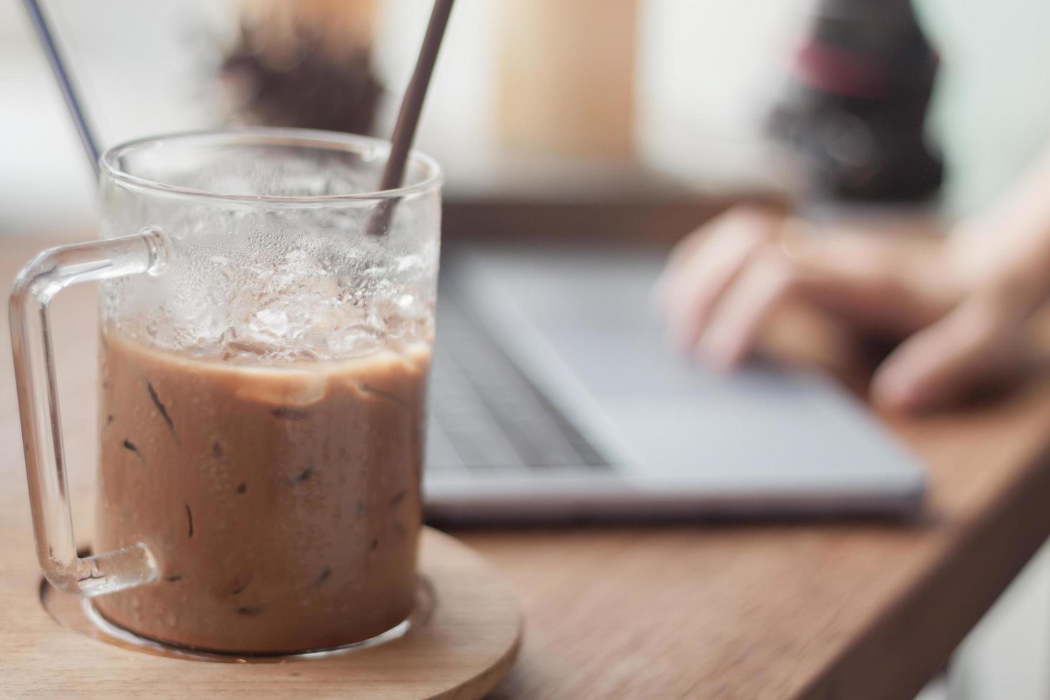 close-up de um café gelado com uma pessoa trabalhando em segundo plano foto