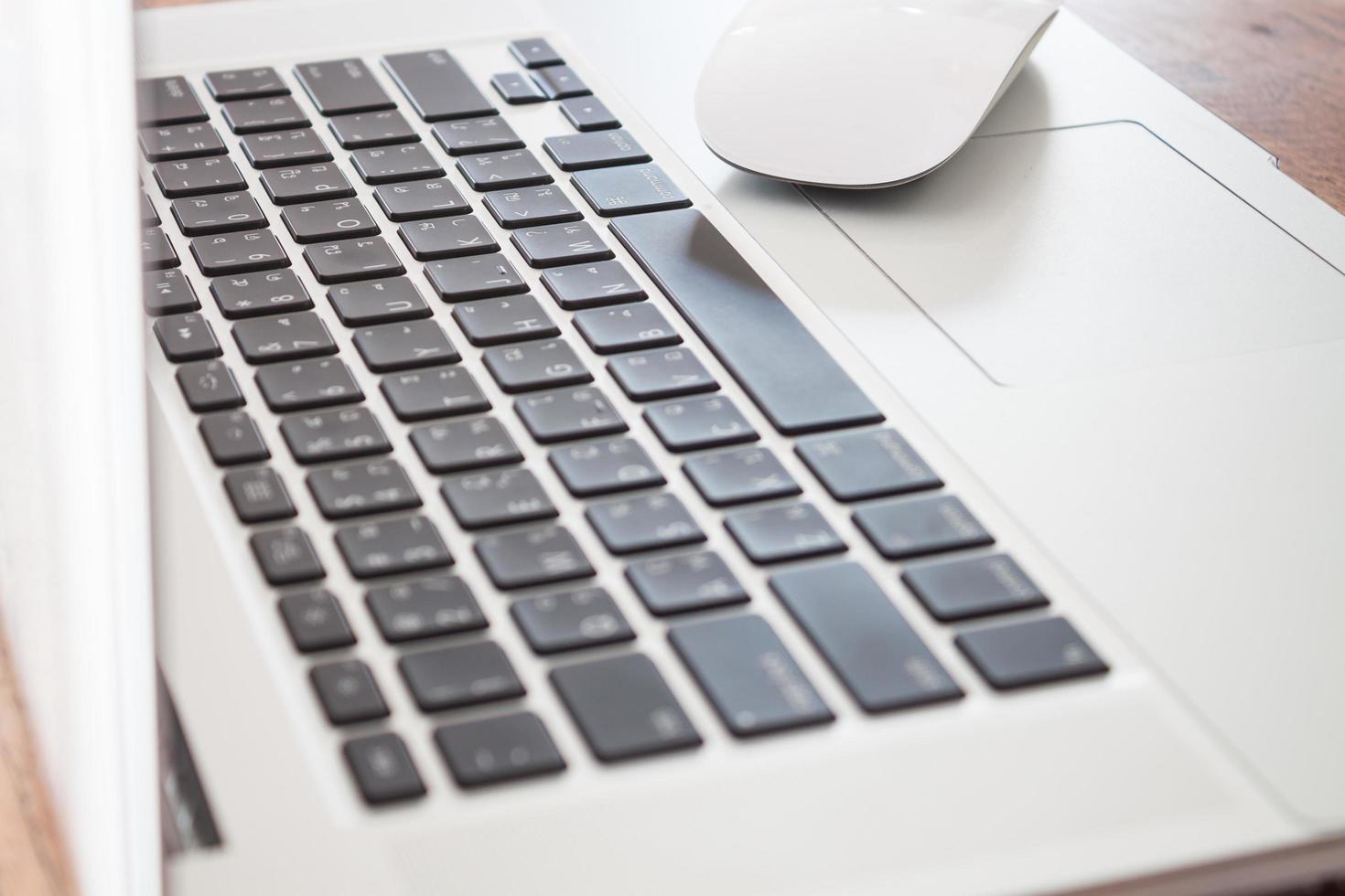 close-up de um laptop branco com um mouse foto