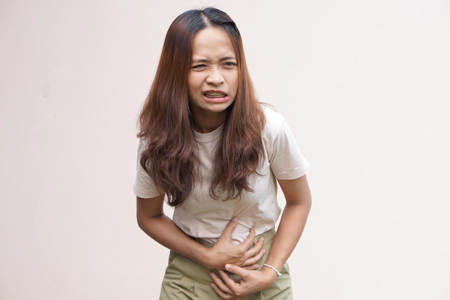 mulher sofre de estômago gastrite crônica conceito de inchaço do abdômen foto