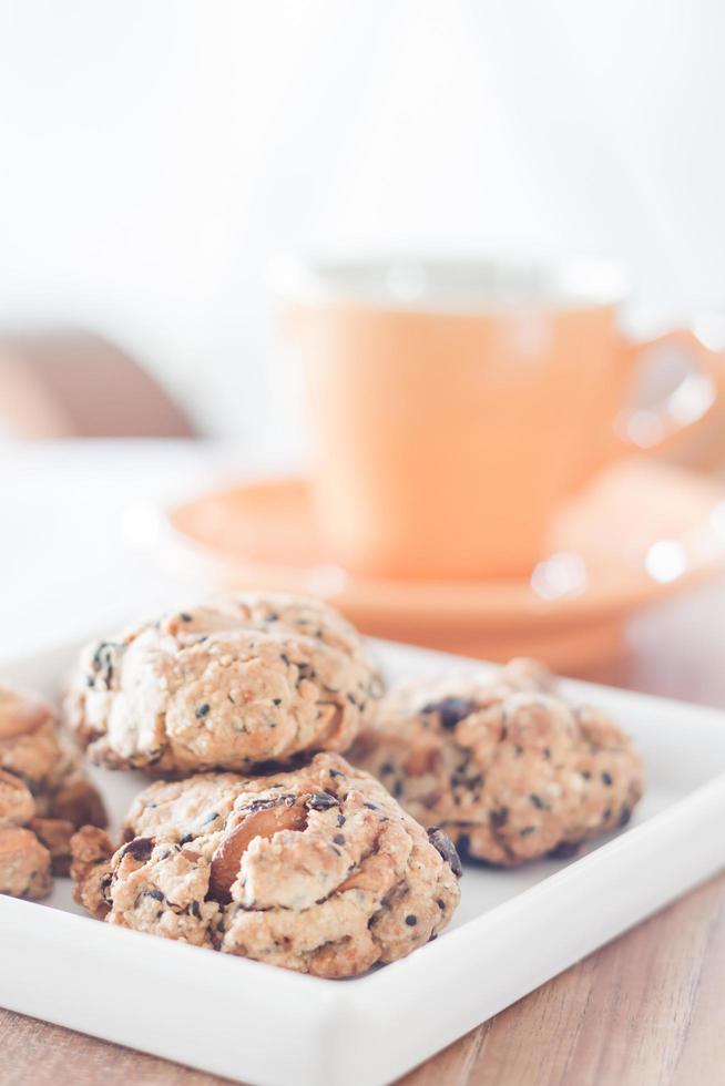 biscoitos saudáveis em um prato branco com uma xícara de café foto