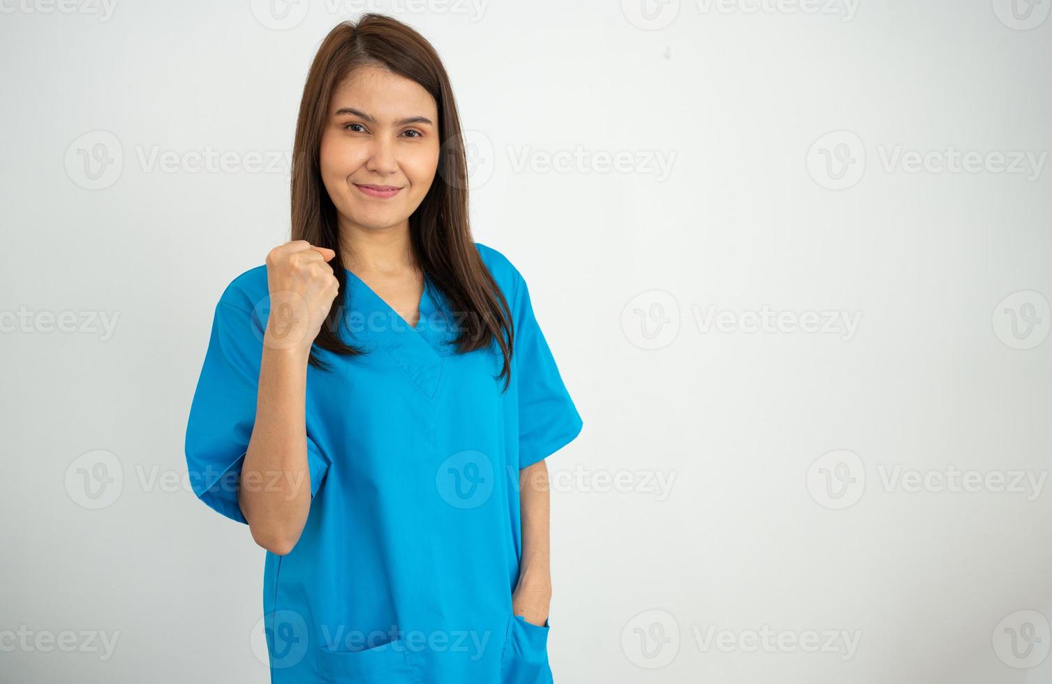 retrato de médica asiática confiante, feliz e sorridente, médica ou enfermeira vestindo uniforme de avental azul sobre fundo branco isolado foto