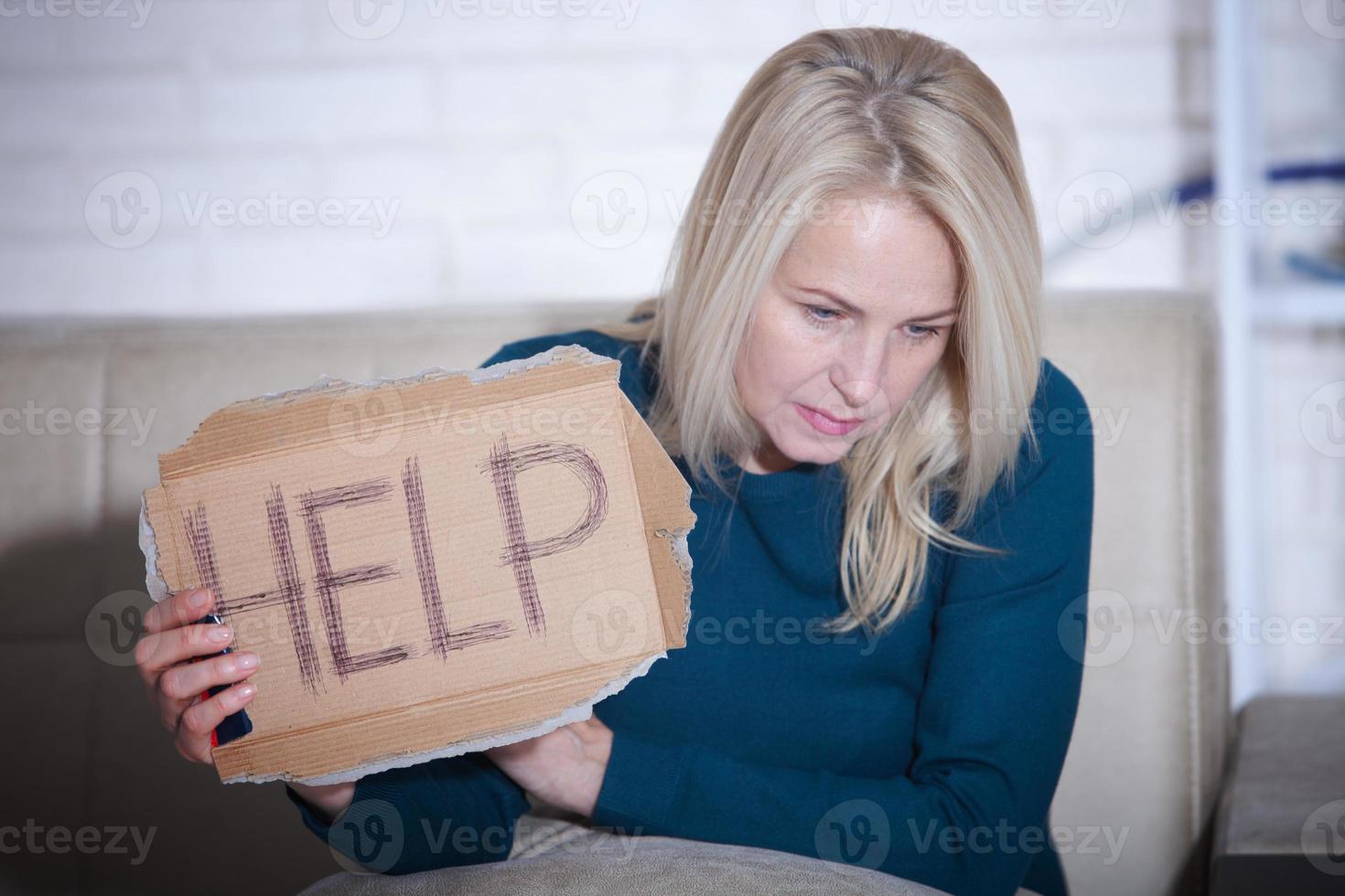 conceito de problemas sociais alcoólicos de mulher sentado pedindo ajuda. mulher de meia idade segurando uma placa m pedindo ajuda. foto