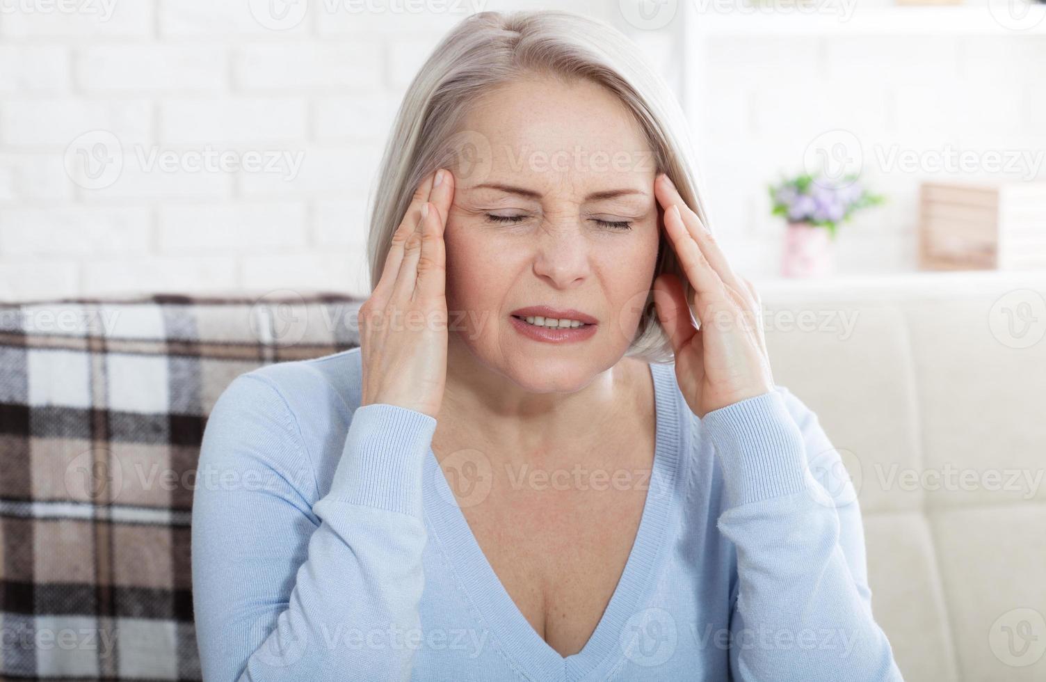 mulher que sofre de estresse ou dor de cabeça fazendo careta de dor enquanto segura a nuca com a outra mão na têmpora, com copyspace. foto do conceito com indicação de localização da dor.
